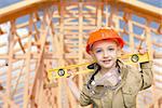 Child Boy Dressed Up as Handyman in Front of New House Framing.