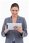 Smiling tradeswoman using her tablet computer against a white background