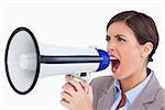 Close up of female entrepreneur yelling through megaphone against a white background