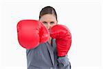 Tradeswoman with boxing gloves attacking against a white background