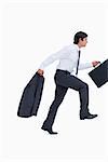 Side view of sprinting businessman with suitcase and jacket against a white background