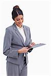 Smiling female entrepreneur taking notes on clipboard against a white background