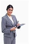Smiling female entrepreneur with clipboard and pen against a white background