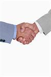 Close up side view of shaking hands against a white background