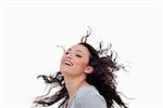 Smiling woman flipping her hair against a white background