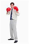 Businessman with his boxing gloves ready to fight against a white background