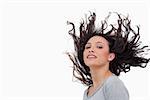 Sensual looking woman flipping her hair against a white background