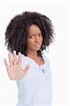 Young angry woman making the hand stop sign against a white background