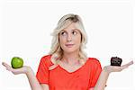 Woman holding a chocolate muffin and a green apple