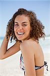 Young woman wearing a bikini while showing a great smile on the beach