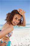 Young woman putting her hand on her forehead to look at the camera while smiling