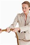 Businesswoman pulling a rope against white background