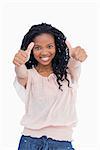 A smiling woman who has her both thumbs up against a white background