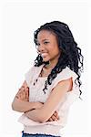 A young smiling woman has her arms folded and is looking away from the camera