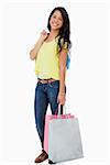 Happy Latin student with shopping bags against white background