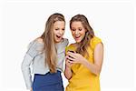 Two voiceless young women looking a smartphone against white background