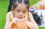 Outdoor upset Asian child. Little girl showing her unhappy face.