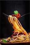 Italian food. Pasta spaghetti with tomato sauce, olives and garnish. Pasta macro on fork