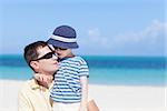 young handsome father and his son hugging at the caribbean tropical beach