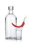 Bottle and shot glass of vodka and red chili pepper. Isolated on white background