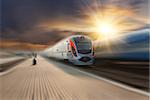 High-speed train passing station with motion blur, majestic clouds and sun on background