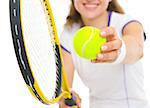 Closeup on racket and ball in hand of tennis player ready to serve