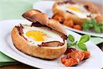 Eggs and bacon baked in buns with cherry tomatoes