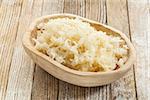 sauerkraut in a rustic wooden bowl against white painted wooden background