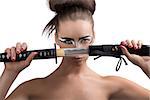 pretty brunette with japan make-up japan sword, she is in front of the face and takes the sword in front of the face