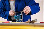 Man Filing a Pipe for a Plumbing Project, in Studio