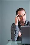 Businessman Using Laptop in Studio