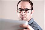 Businessman Looking at Tablet Computer, Studio Shot