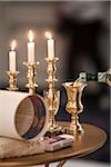 Jewish Wedding Ceremony Items on Table Including Three Lit Candles, and Wine Being Poured into Gold Kiddish Cup Goblet
