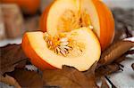 A sliced pumpkin on autumnal leaves