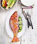 Whole Cooked Snapper Garnished with Shaved Vegetables and Limes; From Above