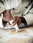 Tortellini filling being piped onto pasta dough squares