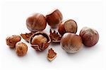 A number of whole hazelnuts and hazelnut shells