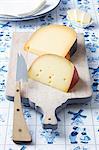 Dutch cheeses (Leerdammer, Old Amsterdam) on a board on a Dutch tablecloth