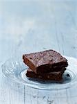 Two brownies on a glass plate