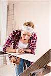 Studio Shot of Young Woman Measuring Lumber