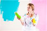 Studio Shot of Young Woman Holding Paint Containers, Deciding Between Paint Colours