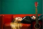 Woman Lying on Sofa with Acoustic Guitar