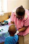 Nurse helping young African boy