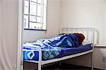 African man resting in a ward bed