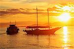 Brazil, Rio de Janeiro State, Angra dos Reis, Ilha Grande, a fishing boat and a schooner silhouetted against the sunset over the Costa Verde, Green Coast,