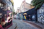 South America, Brazil, Sao Paulo, Vila Madalena, an alley covered in Brazilian graffiti under the yellow neon glow of the Sao Paulo sky