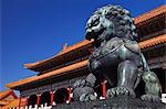 Bronze Chinese male lion holding a ball with its right paw , guarding the entrance to the  Gate of Supreme Harmony in the background, the Forbidden City, Beijing, China.