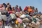 Chad, Kanem, Bahr el Ghazal, Sahel. Passengers ride on top of a grossly over-loaded lorry on the Bahr el Ghazal road from Faya.