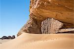 Chad, Kernek, Ennedi, Sahara. A sandstone rock shelter and sand dune near the Kernek Pass.