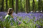 UK, Wiltshire. A young lady enjoys the beauty of the bluebell woods.